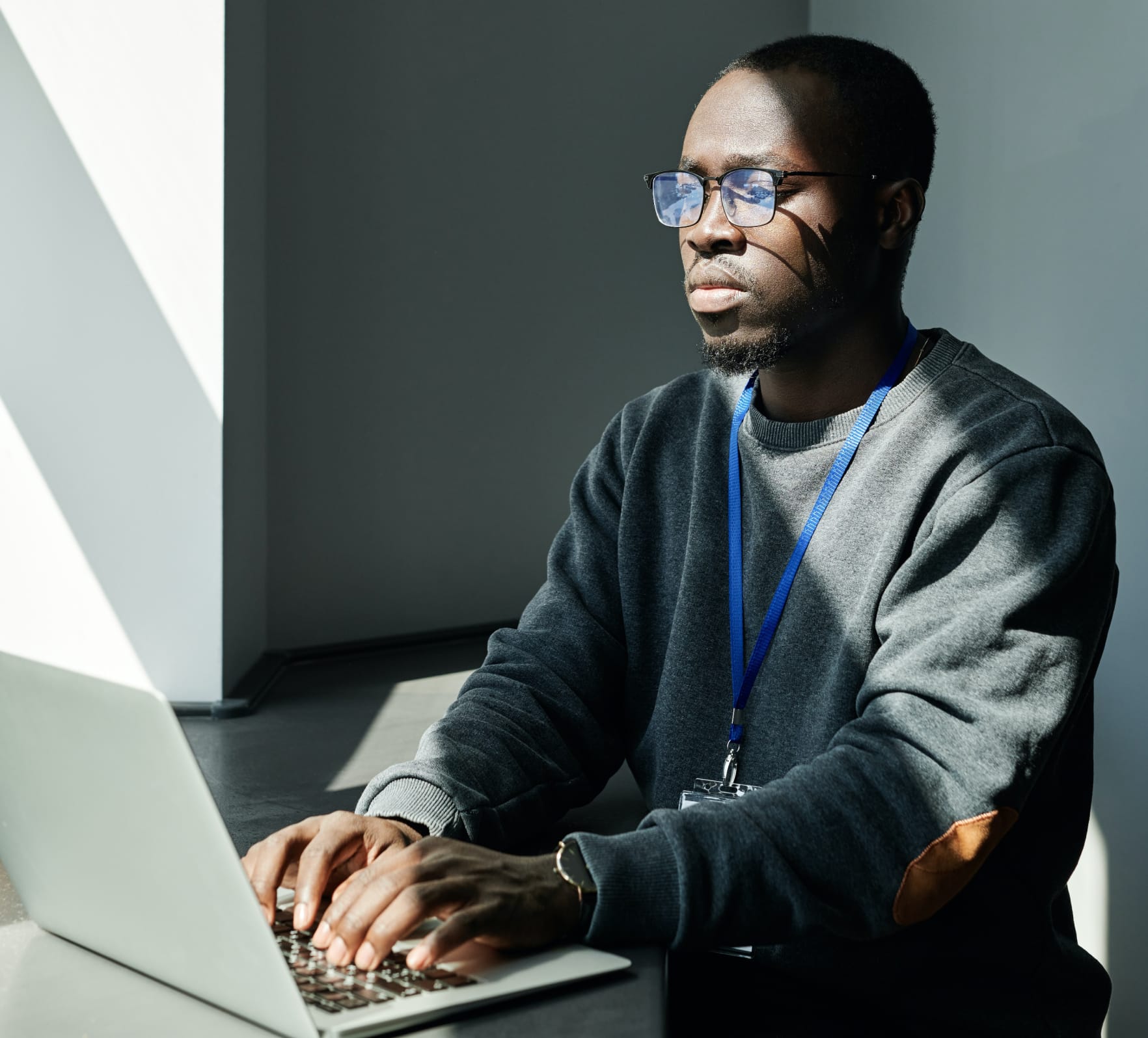 a man sitting at a desk using a laptop