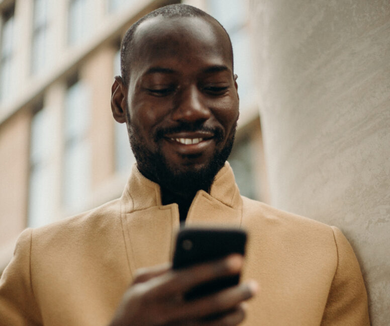 a man smiling while holding a phone