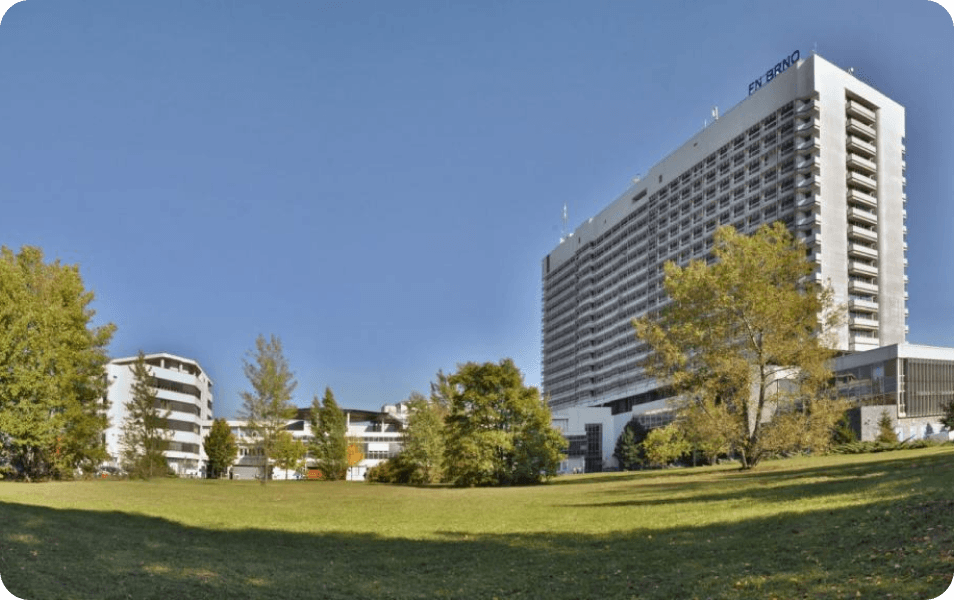 A Large Building Surrounded By Trees And Grass