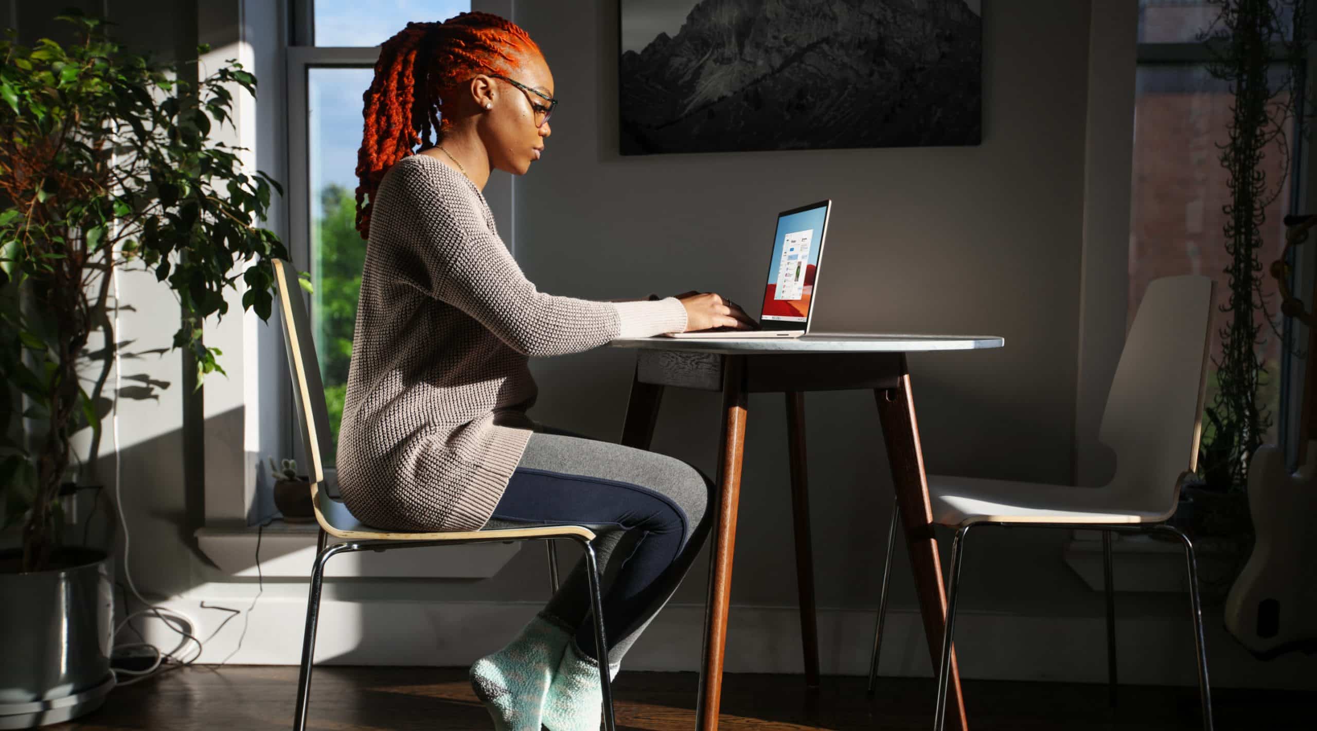a woman sitting at a table using a laptop